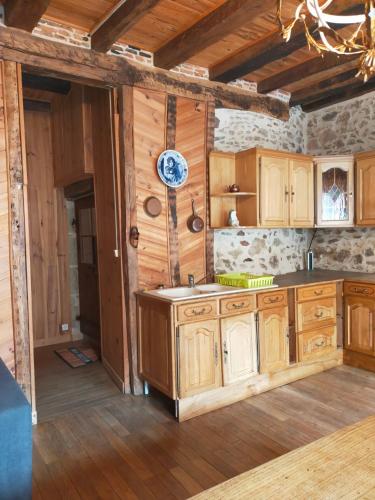 a kitchen with wooden cabinets and a clock on the wall at maison médiéval pour six personnes in Saint-Benoît-du-Sault
