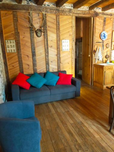 a living room with a blue couch with colorful pillows at maison médiéval pour six personnes in Saint-Benoît-du-Sault
