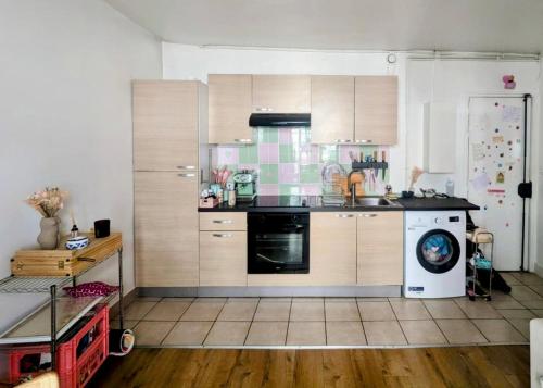 Il comprend une cuisine équipée d'une cuisinière et d'un lave-vaisselle. dans l'établissement Appartement cosy Batignolles, à Paris