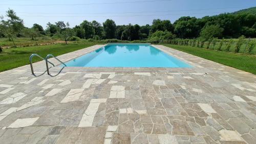 a swimming pool on a patio with a stone floor at Agriturismo La Taverna in Sovicille