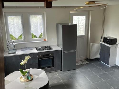 une cuisine avec un réfrigérateur et une table à l'intérieur dans l'établissement TY ROZ beau gîte tout rénové en bord de mer, à Perros-Guirec