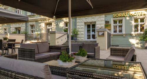 a patio with chairs and tables and a building at SORAT Hotel Cottbus in Cottbus