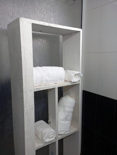 a white shelf with white towels in a bathroom at Homestay with AC Wi-Fi and Hot Water near Colombo in Peliyagoda