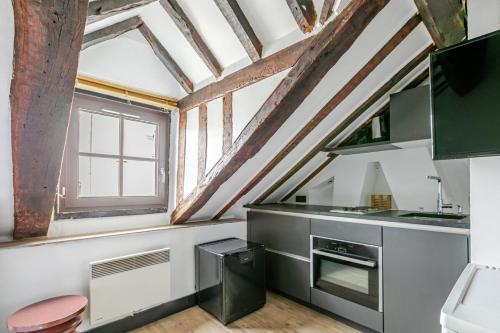 une cuisine avec un plafond à poutres apparentes dans l'établissement Studio cosy pour 2 au cœur de Paris, à Paris
