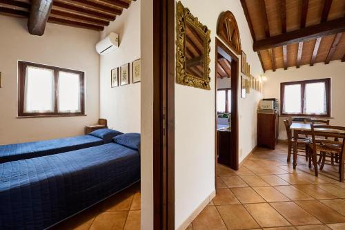 a bedroom with a blue bed and a dining room at Poggio Diavolino - Suvereto in Suvereto