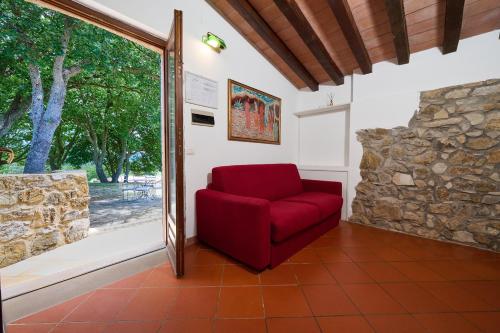 a red chair in a room with a window at Poggio Diavolino - Suvereto in Suvereto