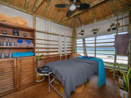 a bedroom with a bed and a ceiling fan at San Martinho Vila Azul in Vila Praia Do Bilene