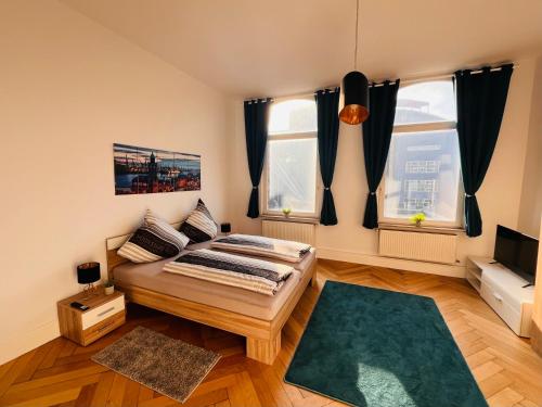 a bedroom with a bed and two windows at Ferienwohnung Reeperbahn Ecke Große Freiheit in Hamburg