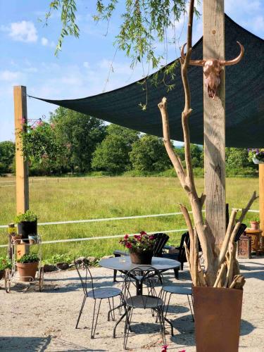 a table and chairs and a table with a tree at Gîte "La belle vie" in Chamblet