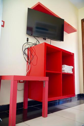 a red cabinet with a tv on top of it at Le Calme a Temara in Temara