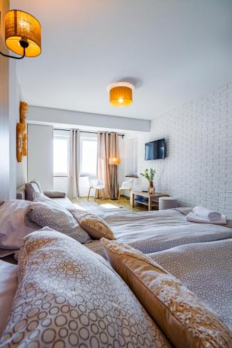 a bedroom with four beds with pillows on them at Mazurskie Apartamenty "Jak Tu Miło!" in Węgorzewo