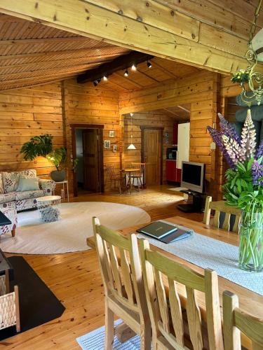 a large living room with a table and chairs at Blockhütte in Alleinlage in Ulricehamn