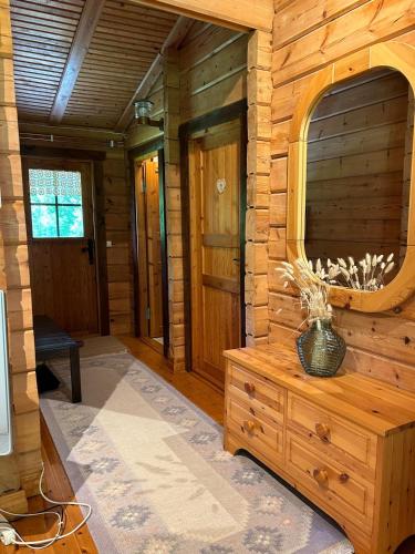 a log cabin hallway with a vase on a wooden dresser at Blockhütte in Alleinlage in Ulricehamn