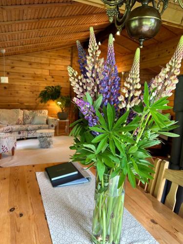 a vase of flowers on a table in a living room at Blockhütte in Alleinlage in Ulricehamn