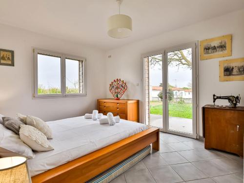 - une chambre avec un grand lit et une porte coulissante en verre dans l'établissement Villa Longevillaise, à Longeville-sur-Mer