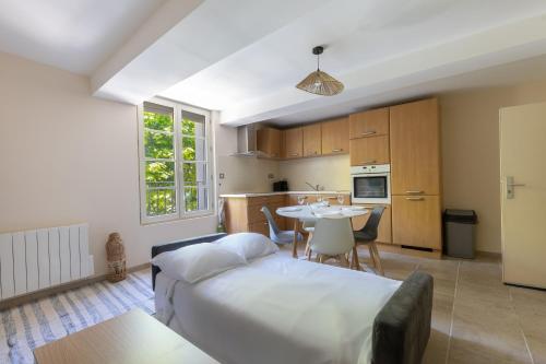 une chambre avec un lit et une table et une cuisine dans l'établissement Le Lavandin - 3 to 4 beds - Hypercentre - Wifi, à Apt