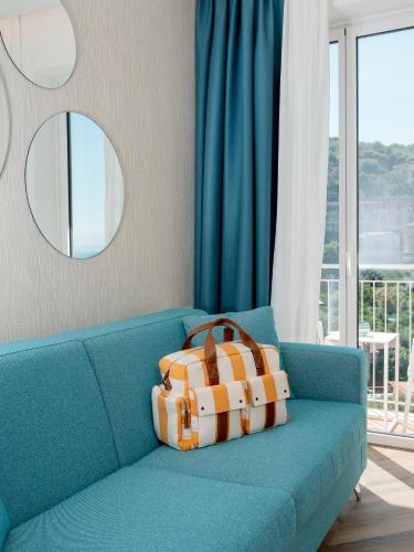 a blue couch with a suitcase on top of it at Hotel Tirrenia in Sorrento