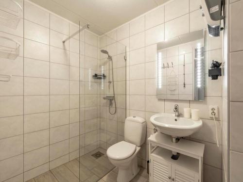 a white bathroom with a toilet and a sink at Beach Apartment 7 for 4 guests in Callanstoog in Callantsoog