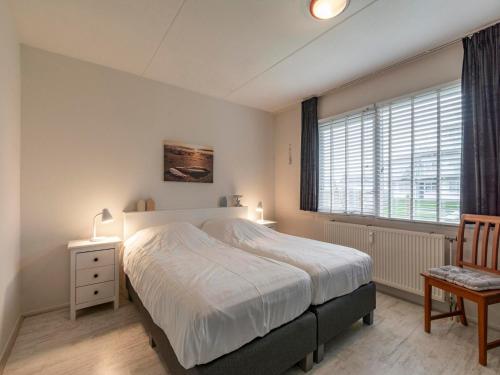 a bedroom with a large bed and a window at Beach Apartment 7 for 4 guests in Callanstoog in Callantsoog