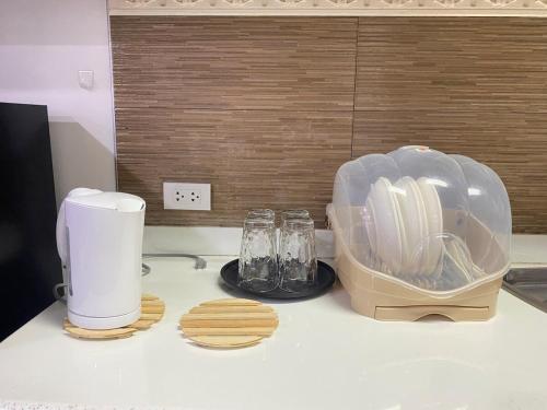a kitchen counter with a toaster and glasses on it at Peaceful Port Away From Home in Manila