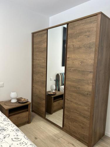 a bedroom with a large wooden closet with a mirror at LabPark modern Melano in Melano