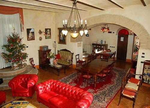 a living room with red leather furniture and a christmas tree at Monastery Biribino in Città di Castello