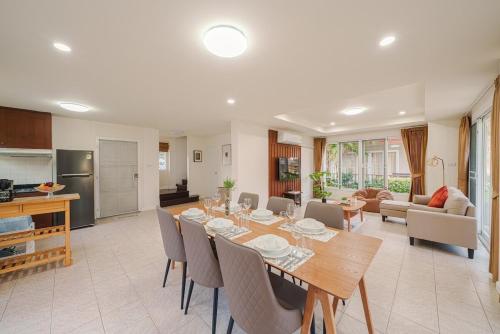 a dining room and living room with a table and chairs at Samran Beach House by May, Cha-am Beach in Cha Am