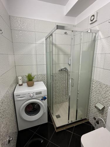 a washing machine in a bathroom with a shower at Sole Inn Apartment in Durrës