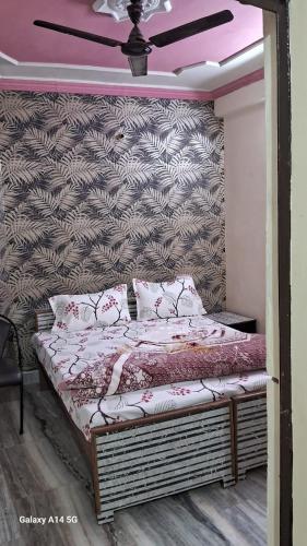 a bed in a room with a wall at Sky Palace Hotel in Auraiya