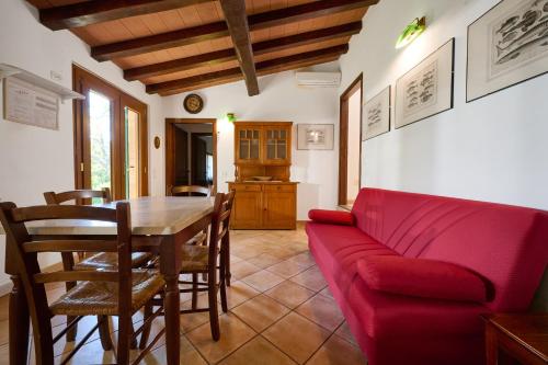 a living room with a red couch and a table at Poggio Diavolino - Suvereto in Suvereto