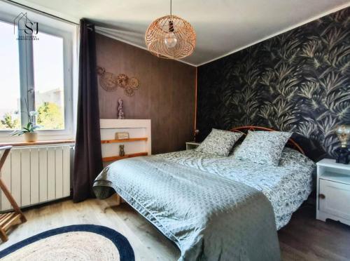 une chambre avec un lit et une grande fenêtre dans l'établissement Maison de village avec terrasse et espace de plaisance au bords du Rhône, à Les Roches-de-Condrieu