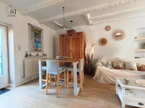 un salon avec une table et un lit dans l'établissement Maison de village avec terrasse et espace de plaisance au bords du Rhône, à Les Roches-de-Condrieu