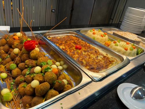 a buffet with several trays of food on a table at Delmar Hotel Matrouh in Marsa Matruh