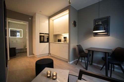a kitchen and dining room with a table and chairs at Sky Hotel City Apartments in Linköping