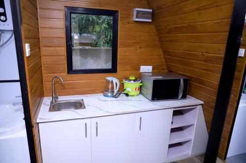 a small kitchen with a sink and a microwave at Greenwin Cabana Resort in Anuradhapura