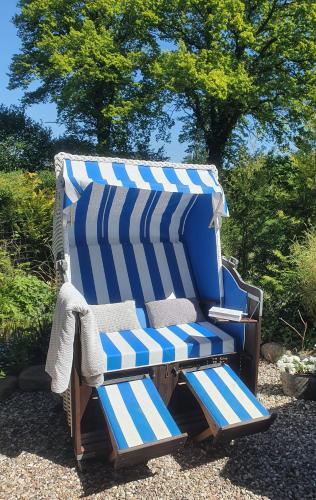 a blue and white beach chair sitting in a yard at BED & BREAKFAST für Individualisten in Gemeinde Scharbeutz, auch Allergiker in Scharbeutz