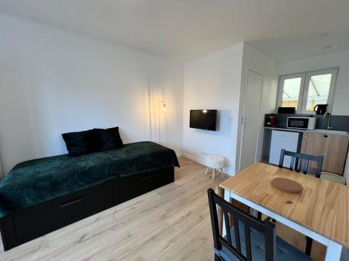 une chambre avec un lit et une table et une cuisine dans l'établissement Marianne élégant studio 2p, à Séné