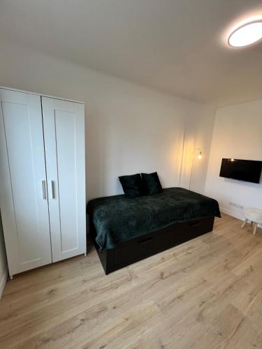 - une chambre avec un lit et une armoire blanche dans l'établissement Marianne élégant studio 2p, à Séné