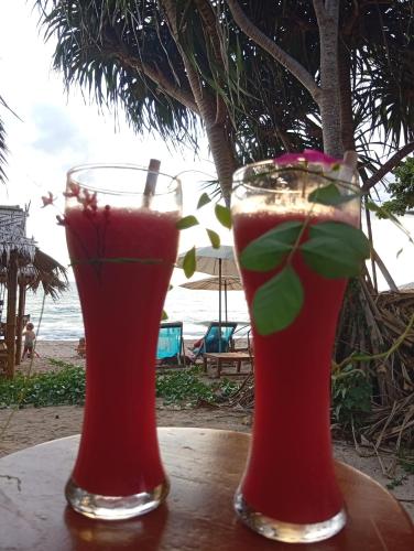 two cocktails sitting on a table near the beach at Blue Moon Bungalow in Ko Bu Bu
