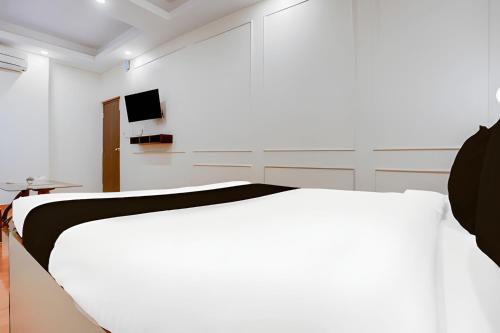 a white room with a bed and a tv at Prince Lodge and Banquet in Khairāni