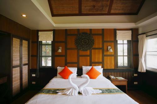two white swans are carved into a bed at Coco Palm Beach Resort - SHA Extra Plus in Mae Nam