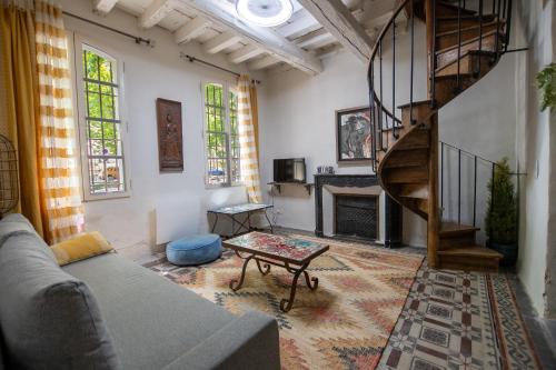 - un salon avec un escalier en colimaçon et un canapé dans l'établissement Taurillon - Grand confort, à Arles