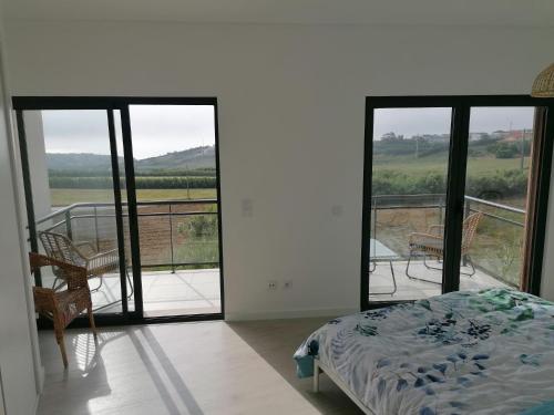 a bedroom with a bed and a balcony with a view at Vilamar - Ribamar in Ribamar