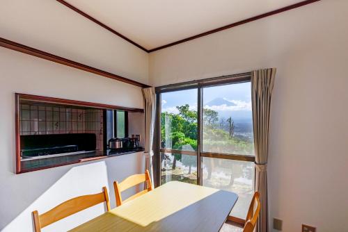 a dining room with a table and a large window at Fuji別邸 in Fujinomiya