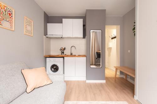 un salon avec un canapé et une cuisine dans l'établissement Studio Raymond IV - élégance et confort, à Toulouse