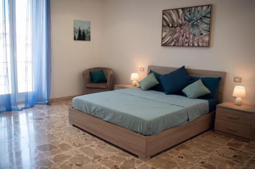 a bedroom with a large bed with blue pillows at Tranquillo Rent and Experiences in Pozzallo