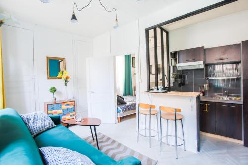 un salon avec un canapé bleu et une cuisine dans l'établissement F1 centre-ville coquet, à Clermont-Ferrand