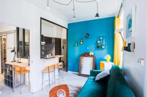 - un salon avec un canapé vert et un mur bleu dans l'établissement F1 centre-ville coquet, à Clermont-Ferrand