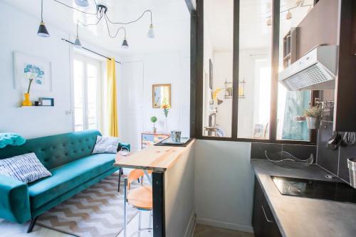 un salon avec un canapé bleu et une table dans l'établissement F1 centre-ville coquet, à Clermont-Ferrand