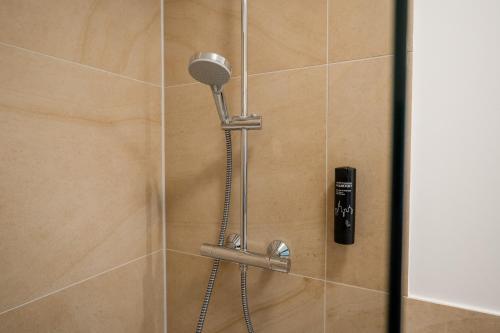a shower with a shower head in a bathroom at Homaris Apartments Nibelungen in Frankfurt/Main